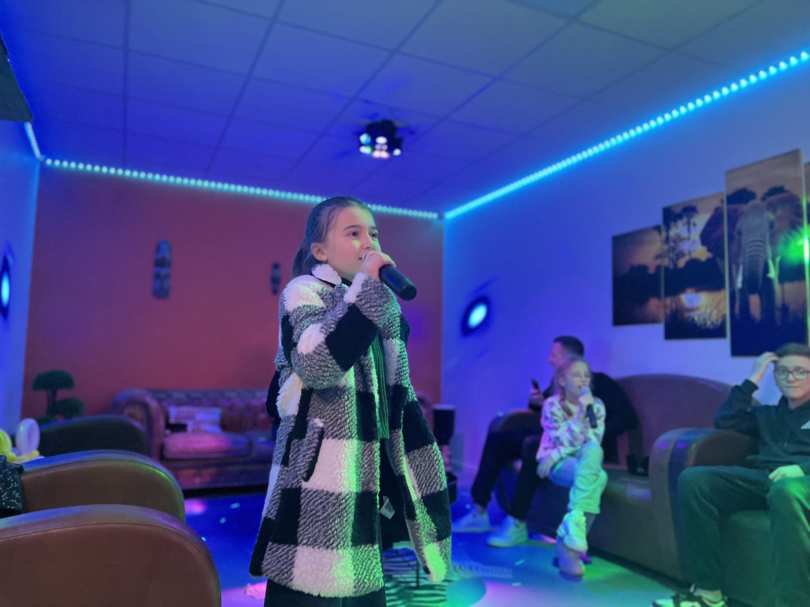 Un groupe chante ensemble dans une salle de karaoké privatisée chez Team Square